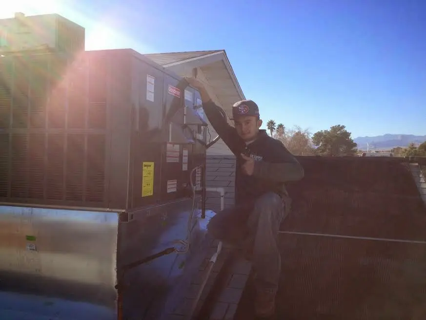 HVAC technician performing Air Duct Cleaning on a rooftop unit in Oak Harbor